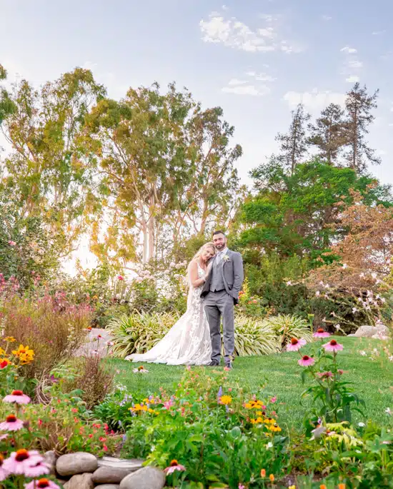Wide-angle wedding portrait using garden flowers as foreground.