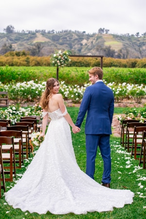 Bride and groom have a cute photo with the wedding venue