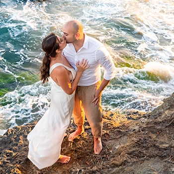 Romantic kiss on rocky shore.