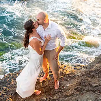 Romantic kiss on rocky shore.