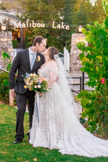 Lake wedding photography: Bride and groom kissing.
