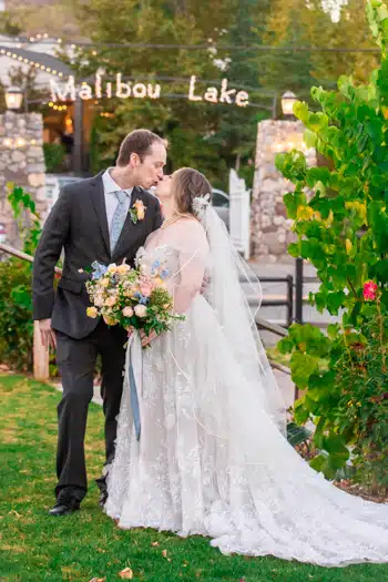 Lake wedding photography: Bride and groom kissing.