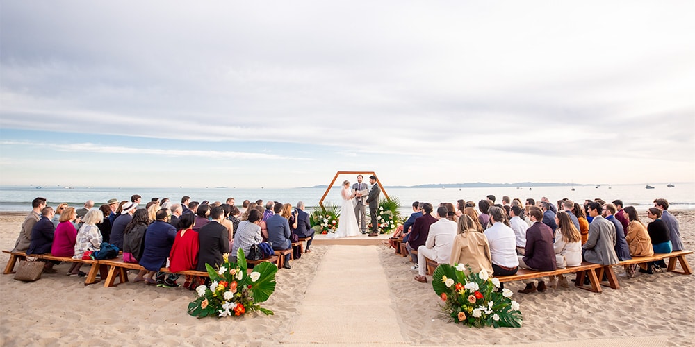 Beach wedding photography: Full view of seaside ceremony.