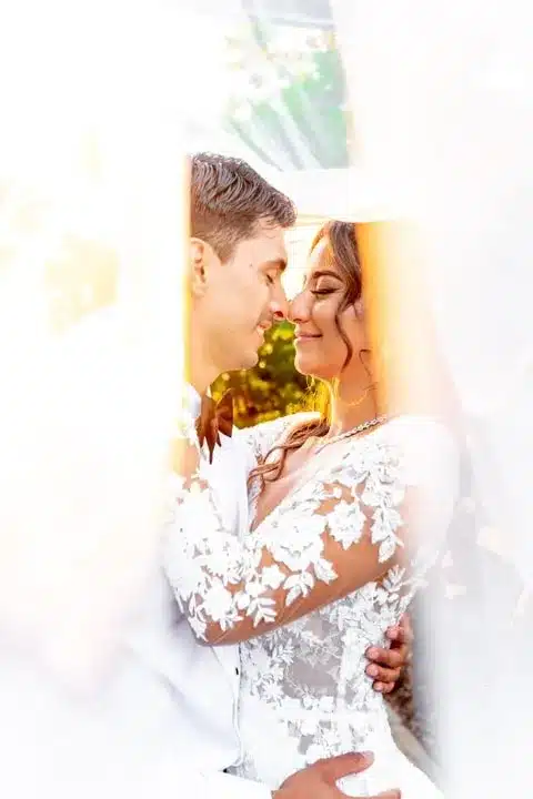 Romantic wedding portrait framed by a flowing veil
