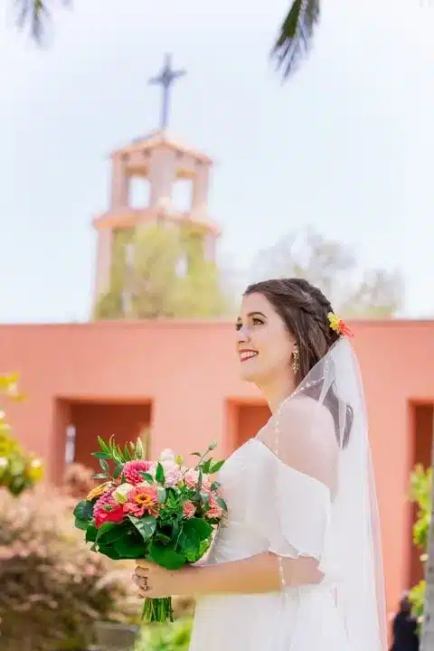 bride holds multicolored flower bouquet.