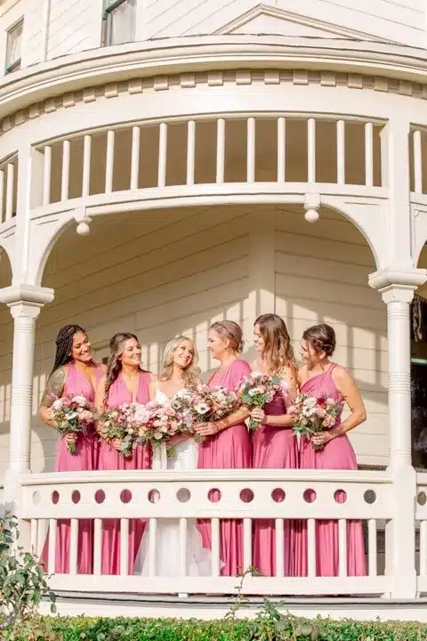 bride and her friends standing and holding matching flower banquets with dress.