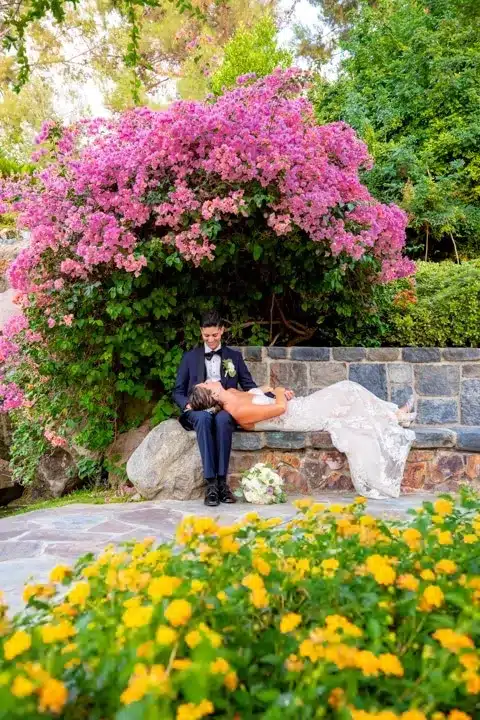 The bride lay down on the groom's lap in a beautiful garden