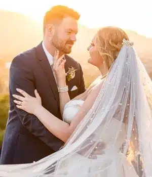 Romantic bride and groom embracing during golden hour sunset